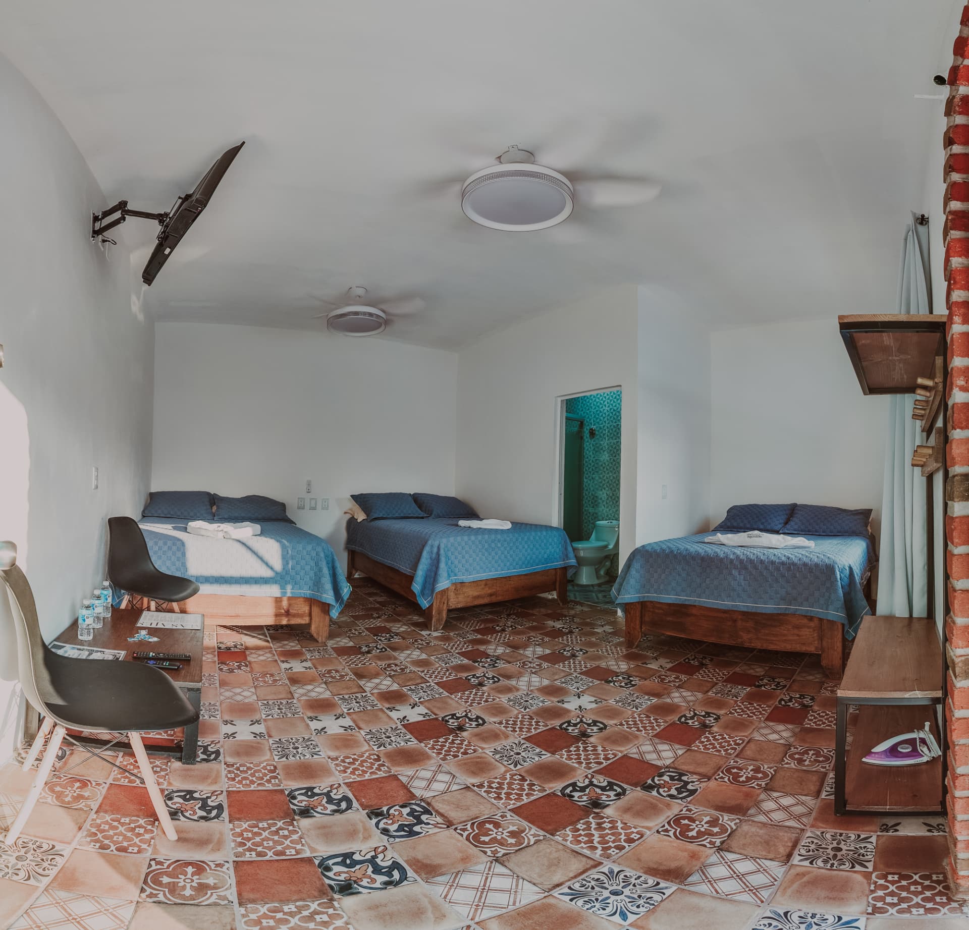 Habitación Triple Deluxe con tres camas matrimoniales y piso de mosaico