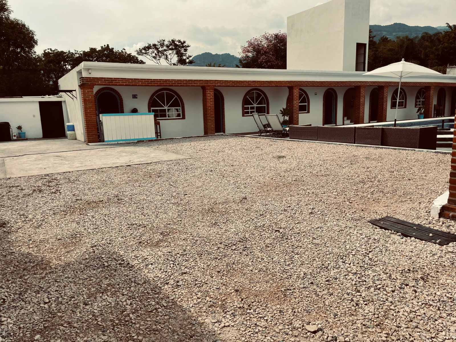 Estacionamiento de grava dentro de Casa Arcos frente a los arcos de ladrillo