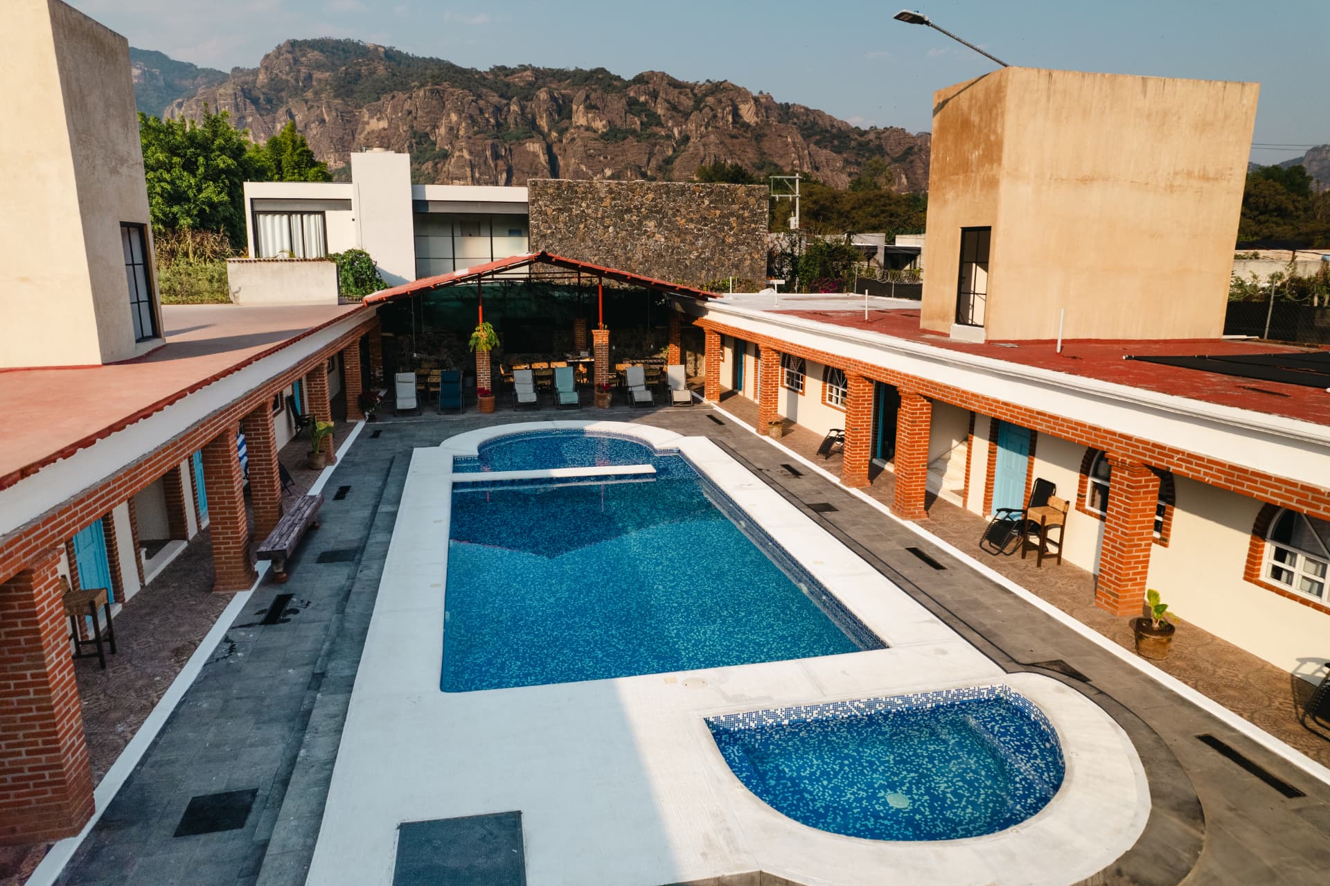 Vista aérea de Casa Arcos Tepoztlán con su alberca, chapoteadero y los cerros del Tepozteco al fondo