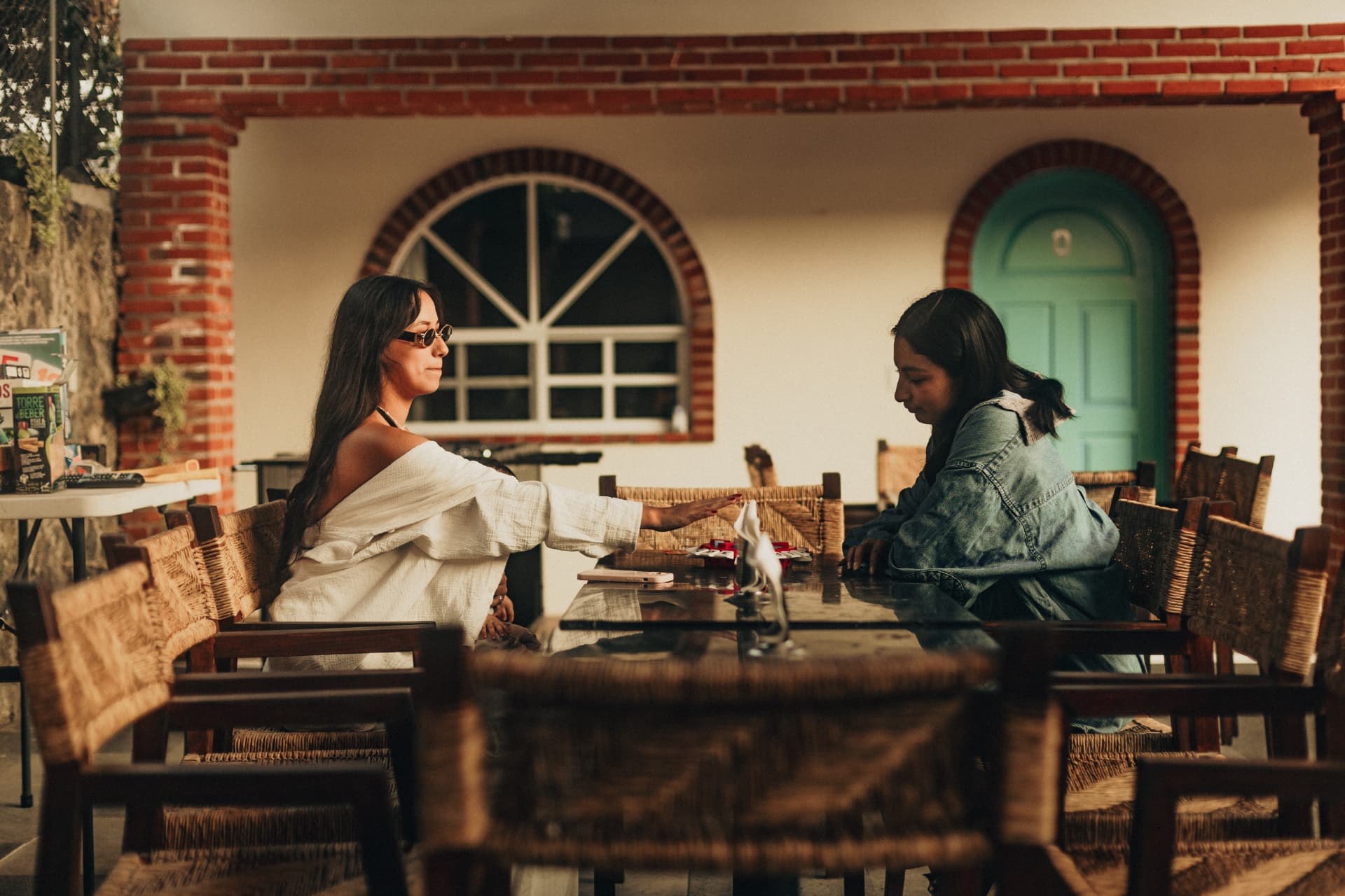 Palapa de Casa Arcos con mesa larga de madera, juegos de mesa y arcos de ladrillo